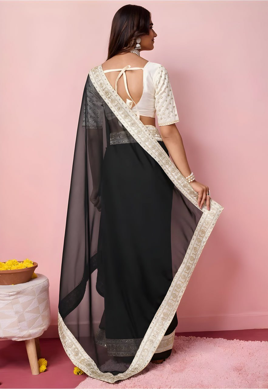 Woman wearing black organza embroidered saree with golden zari work – bridal party wear saree