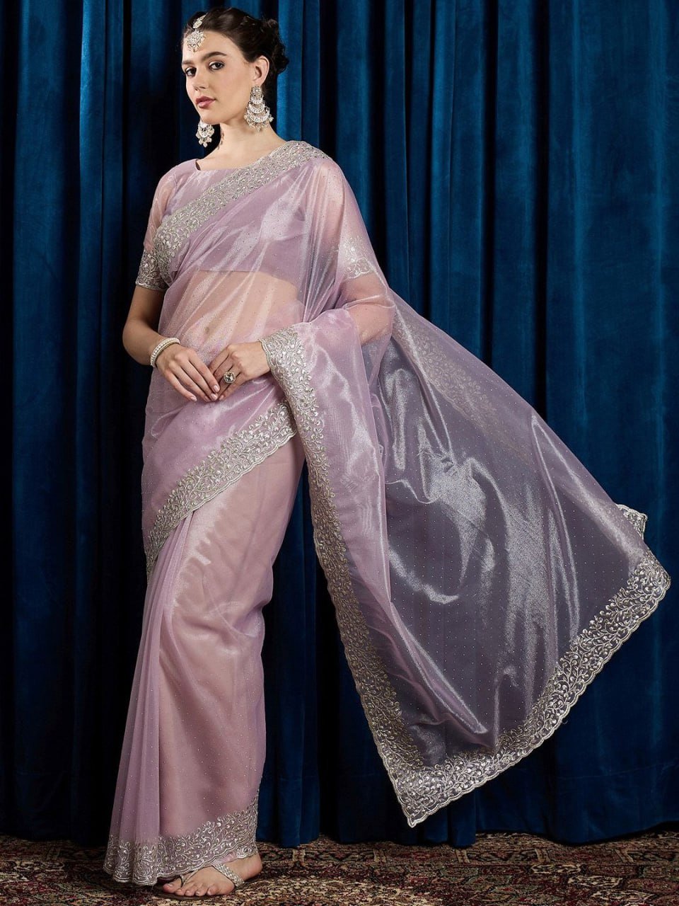 Close-up of pink net saree fabric with hotfix work, cutwork border, and stone embellishments