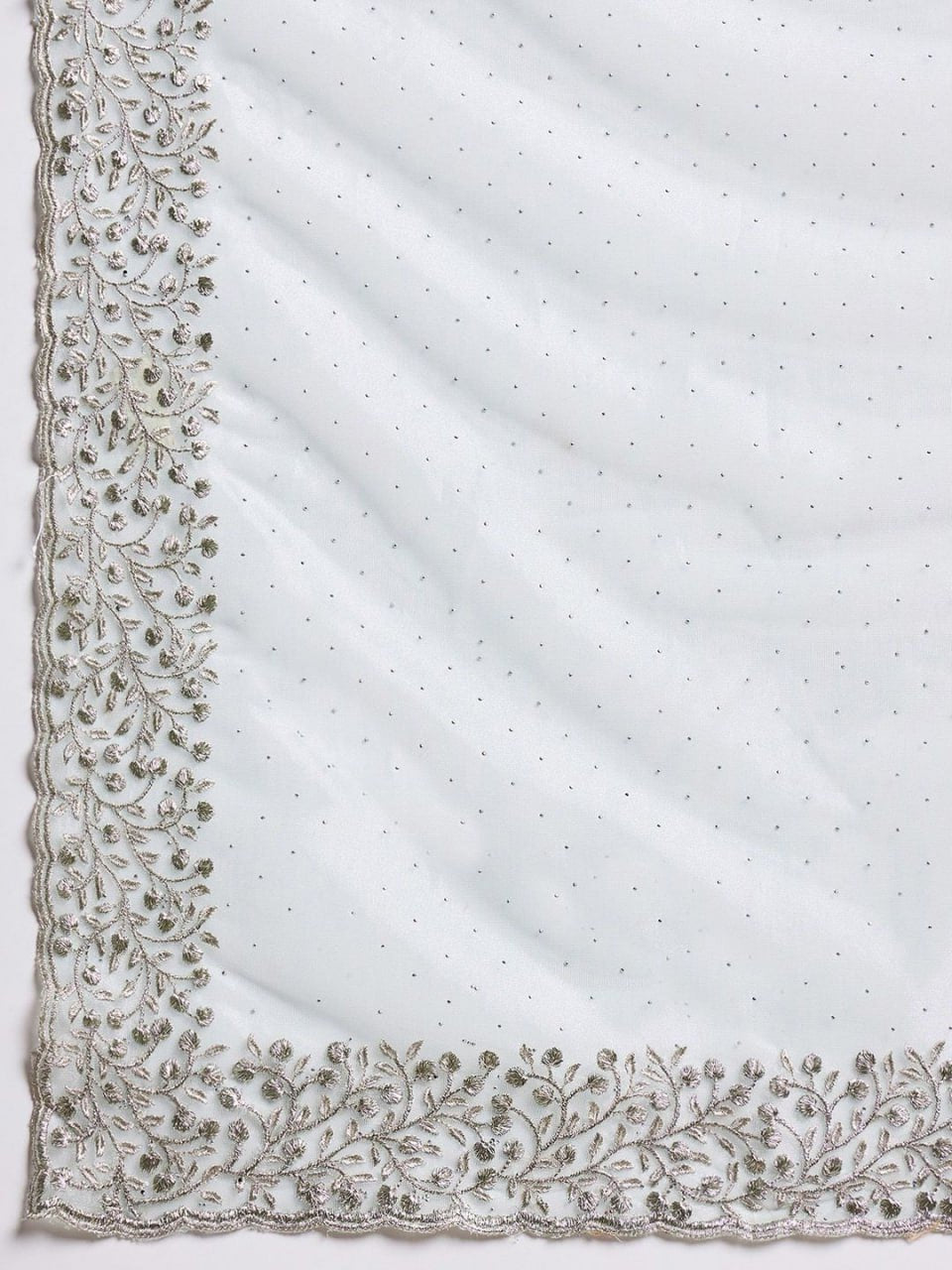 Close-up of sky blue net saree fabric with intricate cutwork and stone embellishment