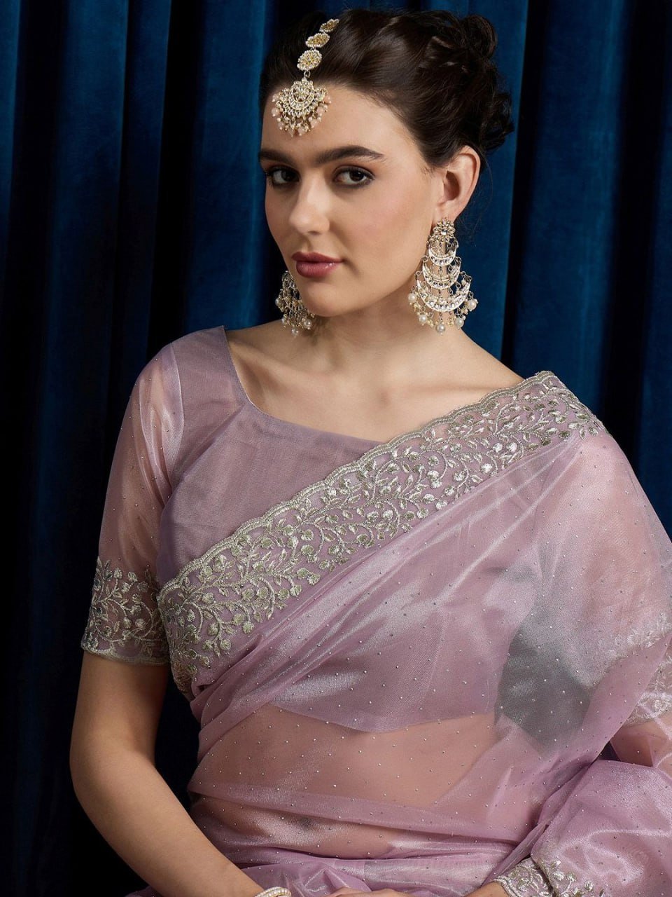 Matching embellished blouse piece of pink hotfix cutwork net saree with beads and stones