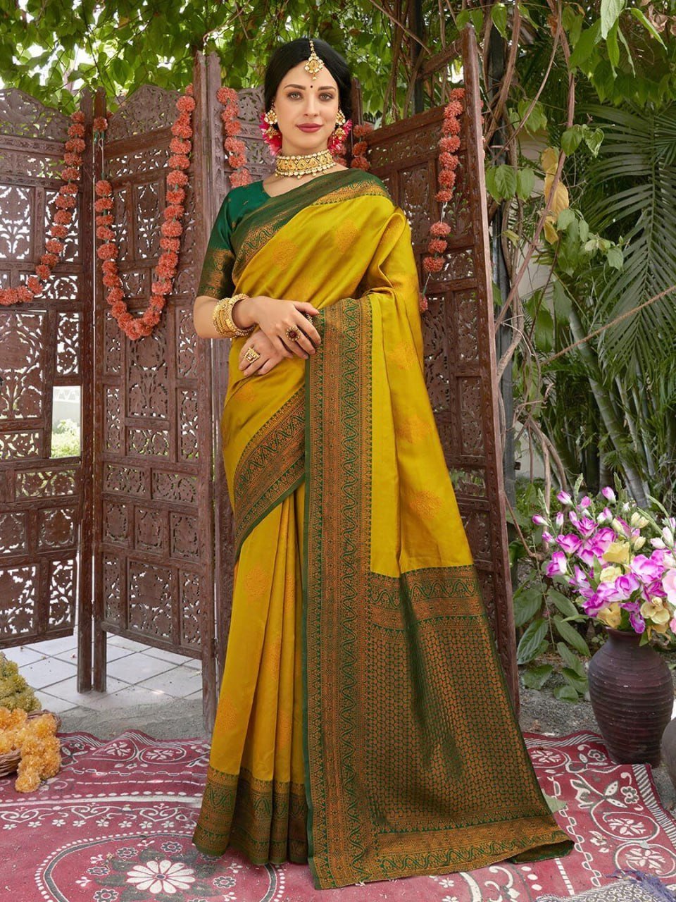 Woman draped in yellow Banarasi soft silk saree with green border and zari motifs, festive ethnic wear outdoors