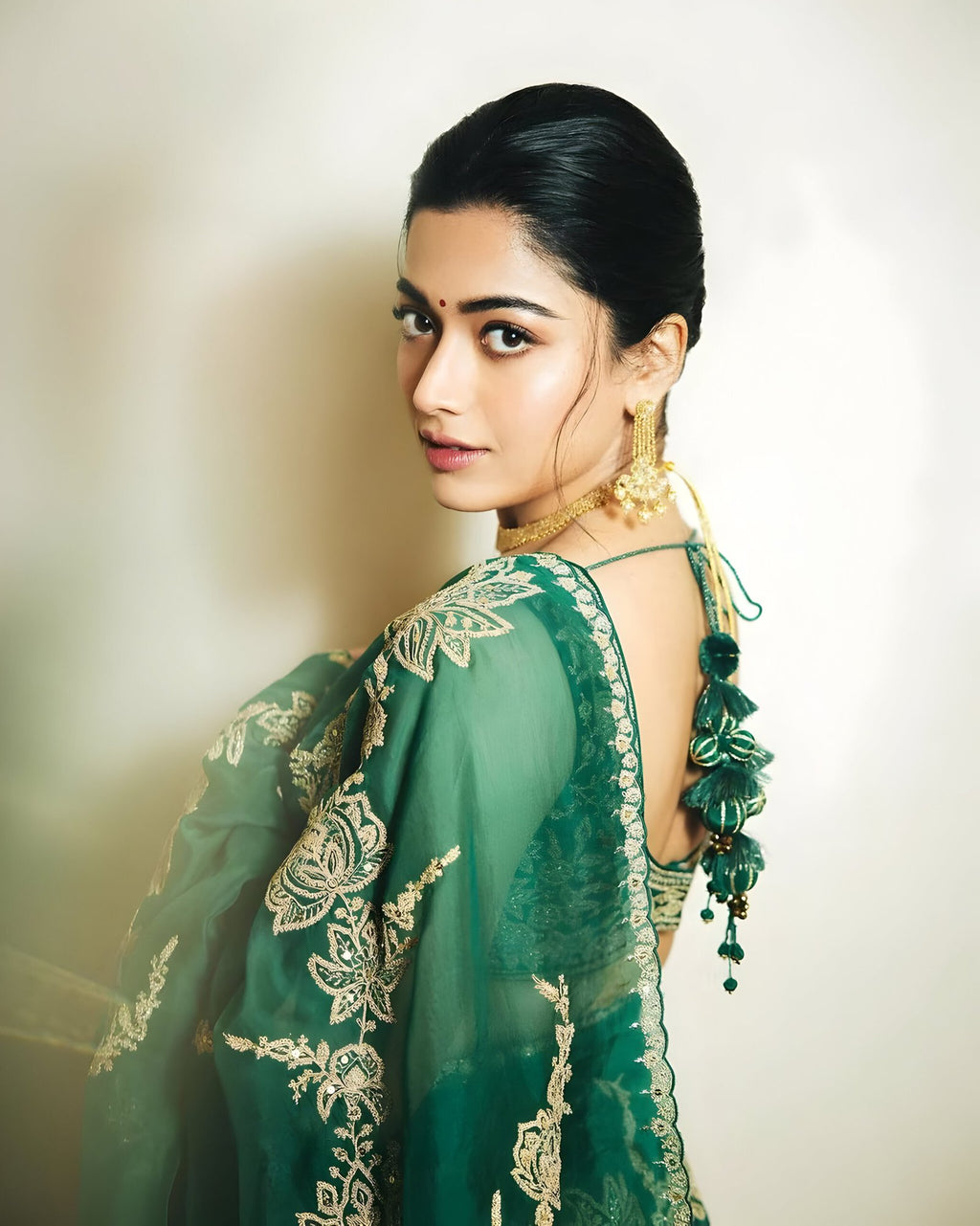 Close-up of green organza silk saree fabric with heavy sequin and zari embroidery – designer detail